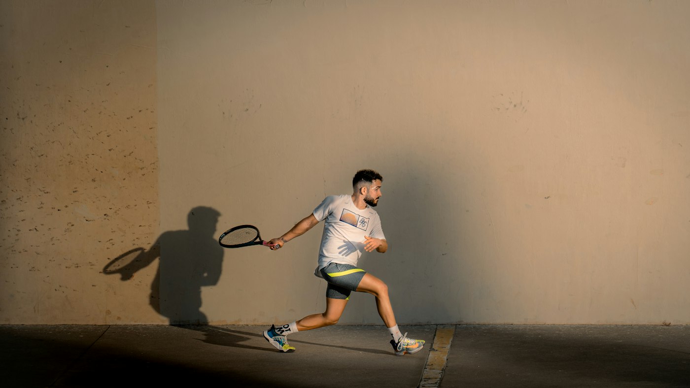 A player hitting a shot on a squash court